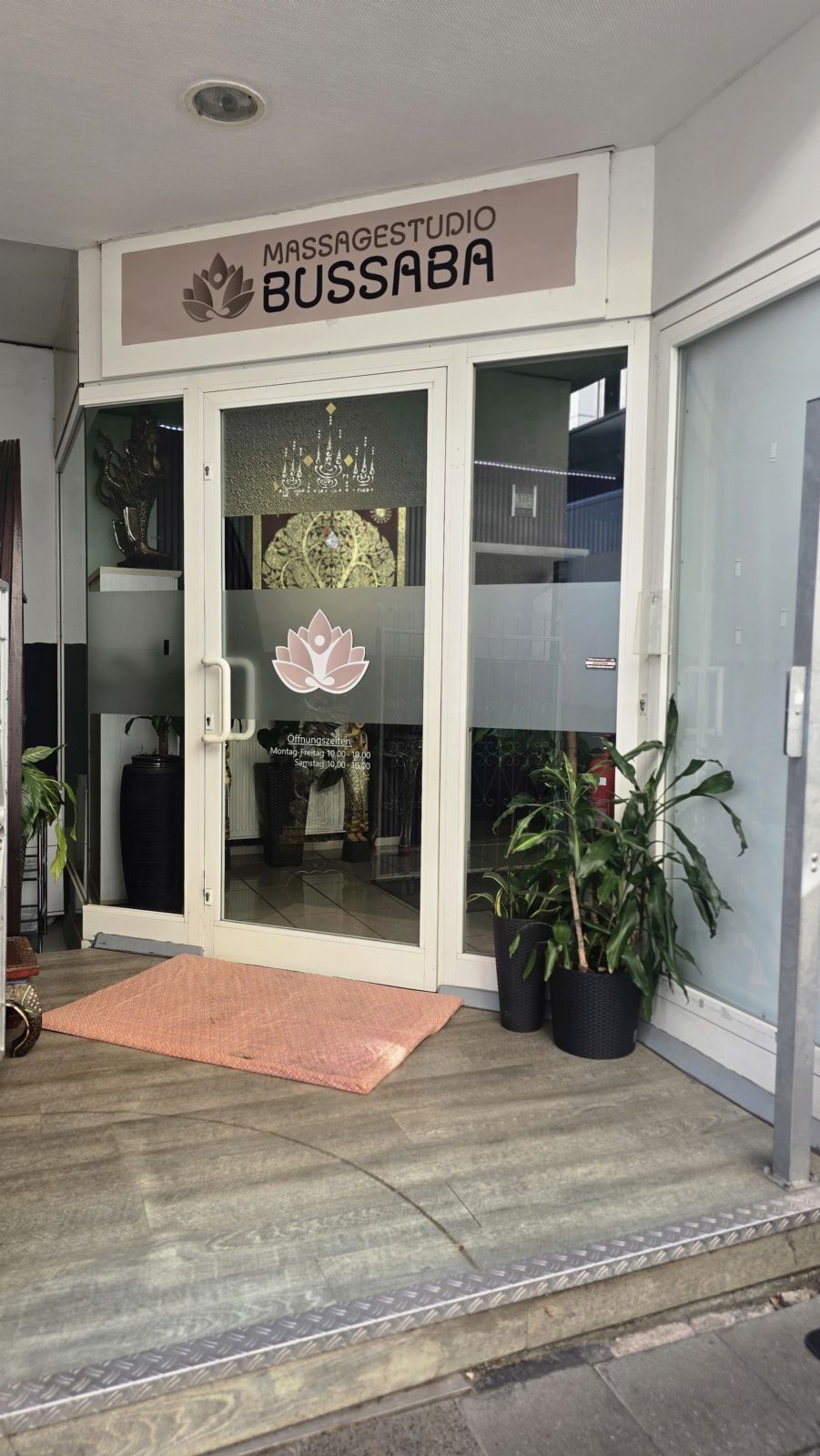 Eingangstür des Massagestudio Bussaba mit Lotusblüte auf der Glastür